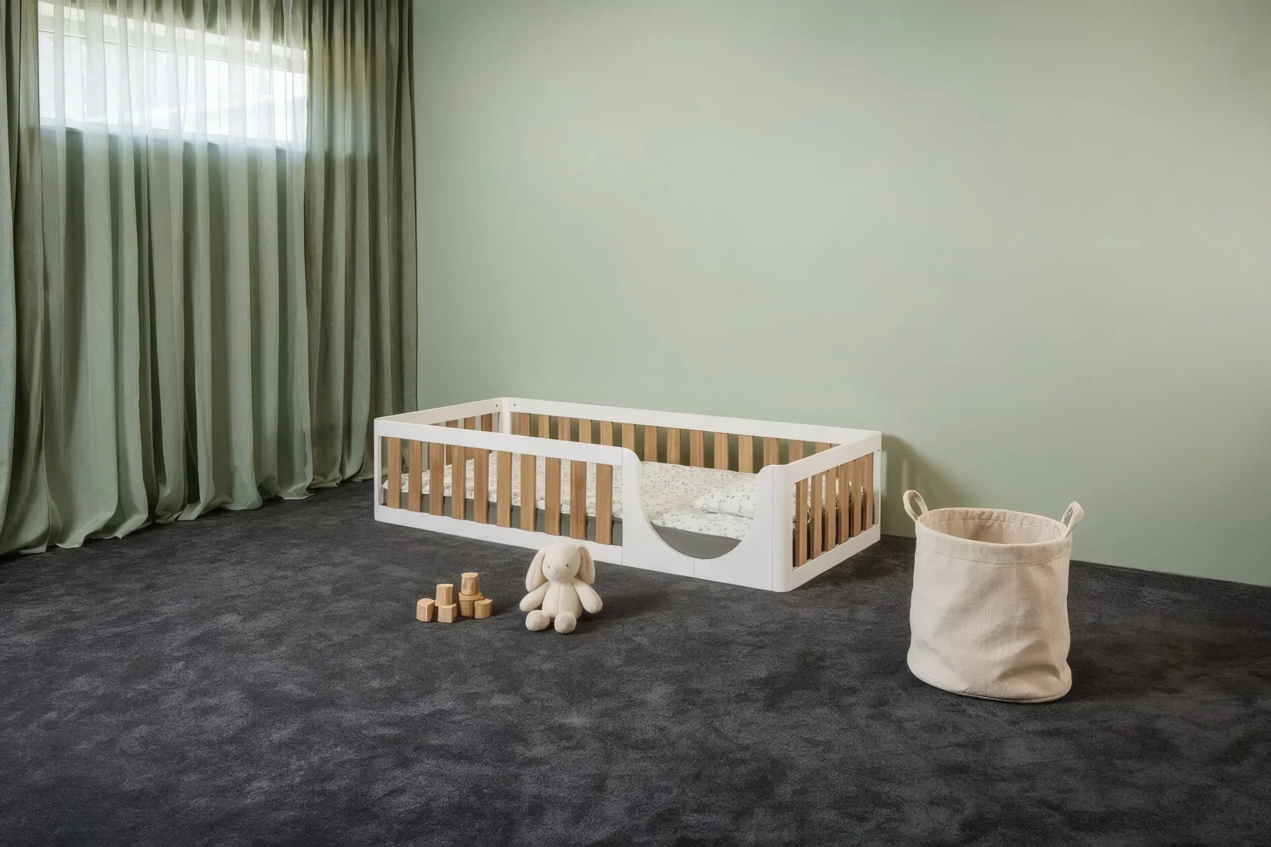 Two-tone white and oak Montessori floor bed in a nursery