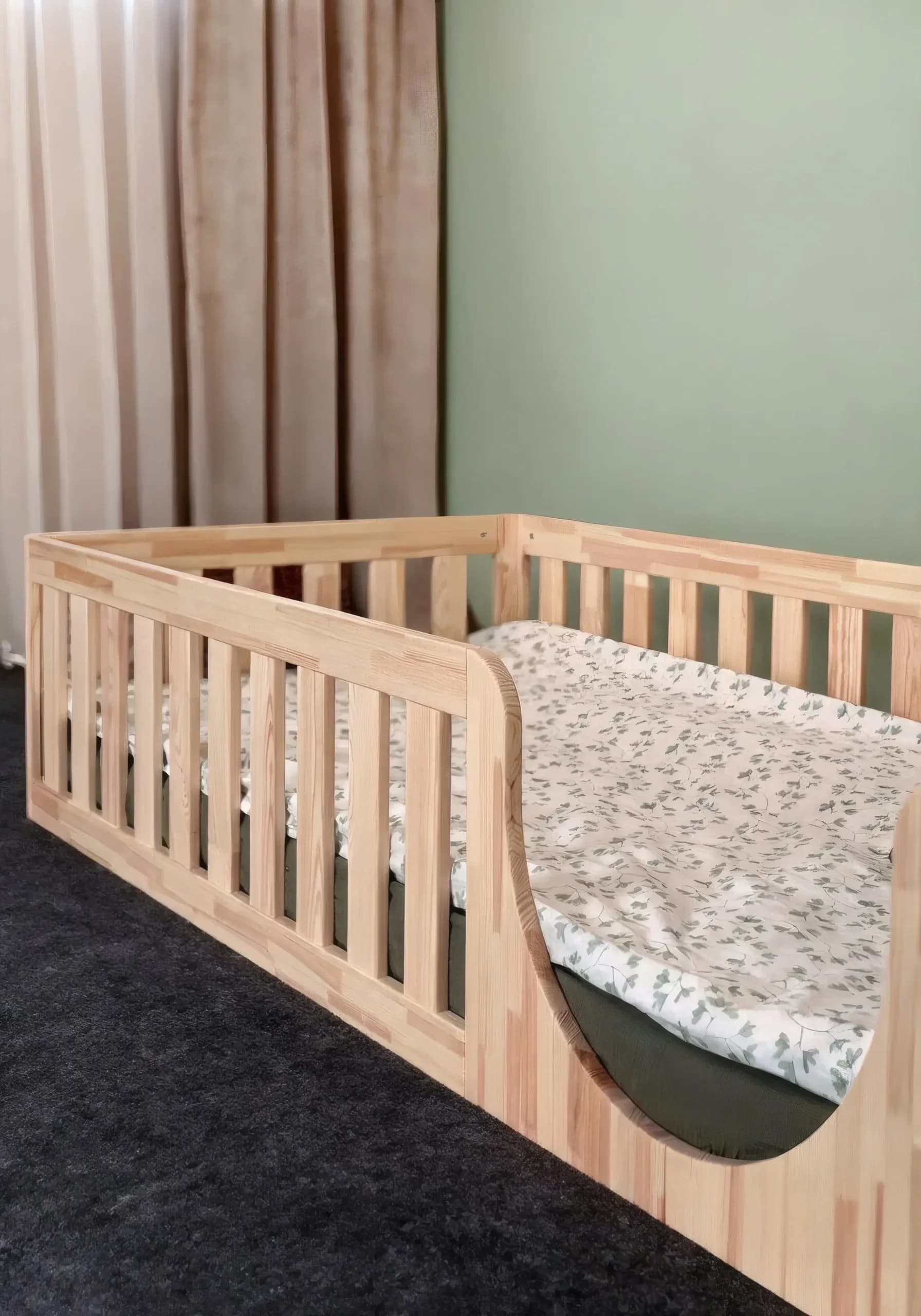 Montessori-Bodenbett mit abgerundetem Einstieg und Bettwäsche, Ansicht vom Fußende
