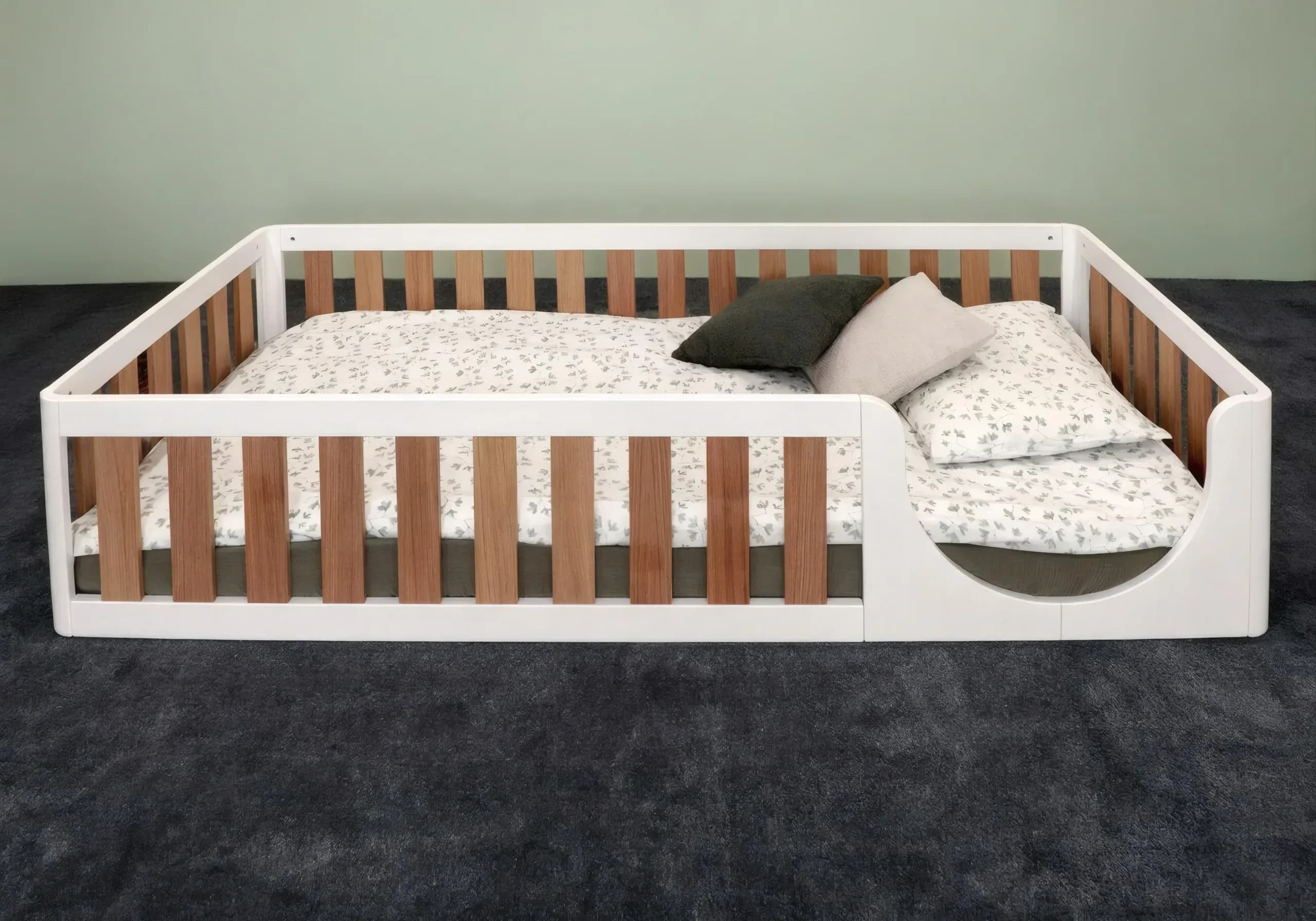 Two-tone floor bed with pillows and bedding, high angled view