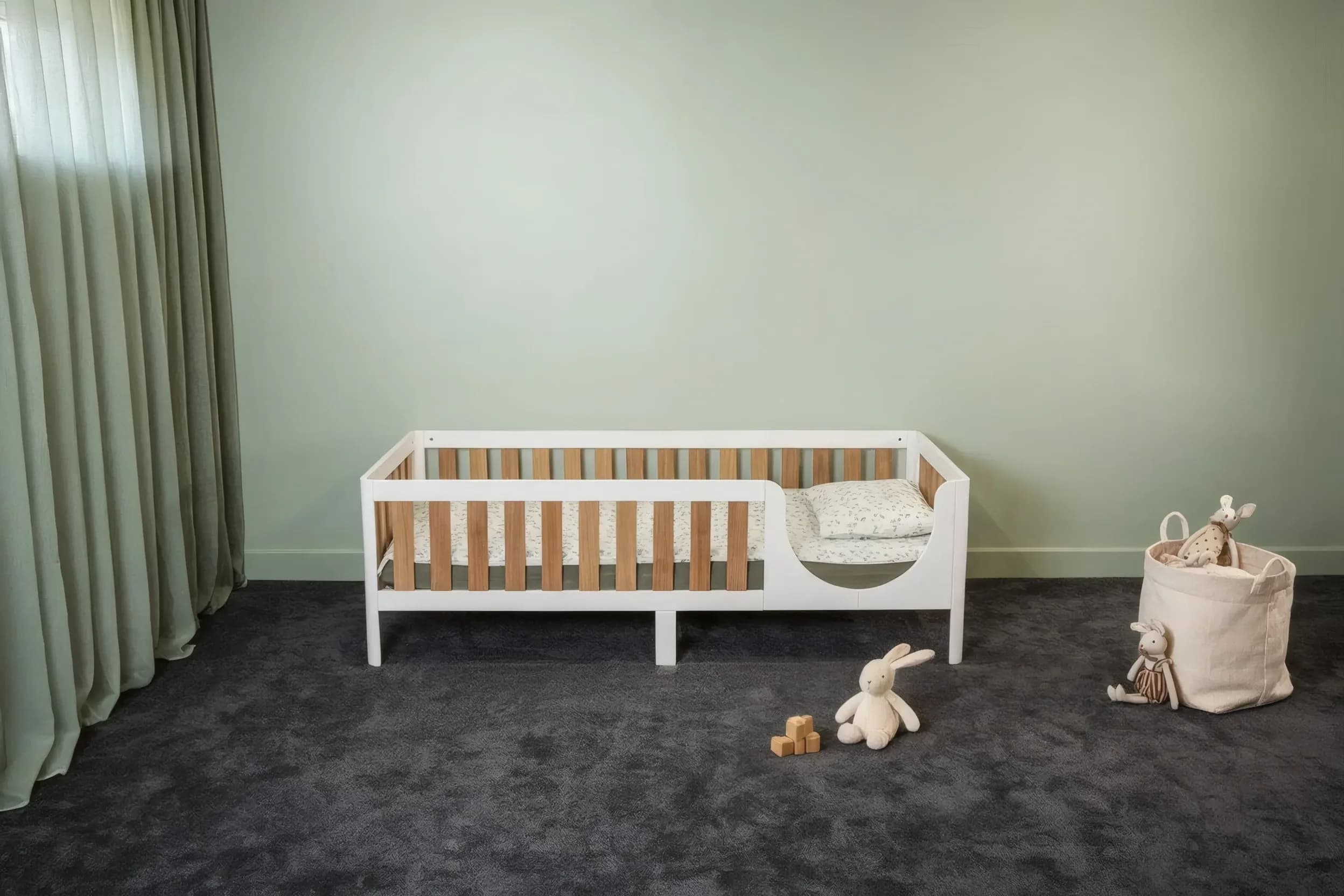 Weißes Bett auf Beinen mit Eichenfurnier-Stäben im Kinderzimmer, Vorderansicht