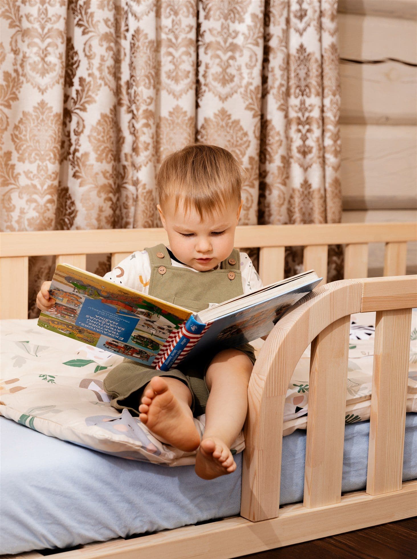 Lit de sol Montessori en bois naturel avec entrée arrondie et bords de protection pour la chambre d'enfant