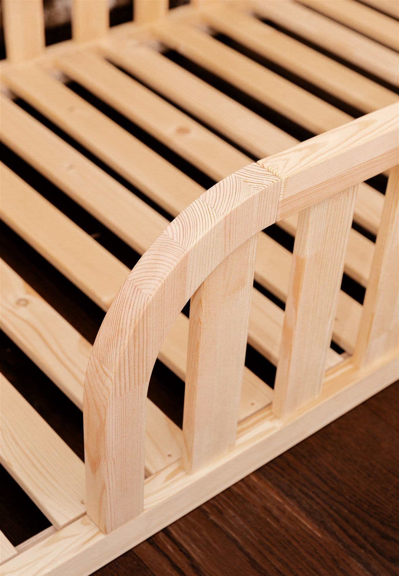Lit de sol Montessori en bois naturel avec entrée arrondie et bords de protection pour la chambre d'enfant