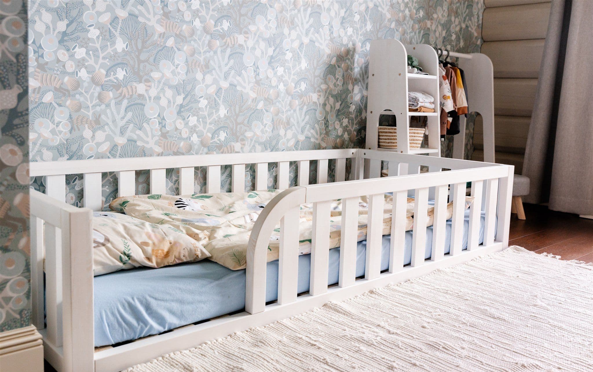 Lit de sol Montessori en bois naturel avec entrée arrondie et bords de protection pour la chambre d'enfant