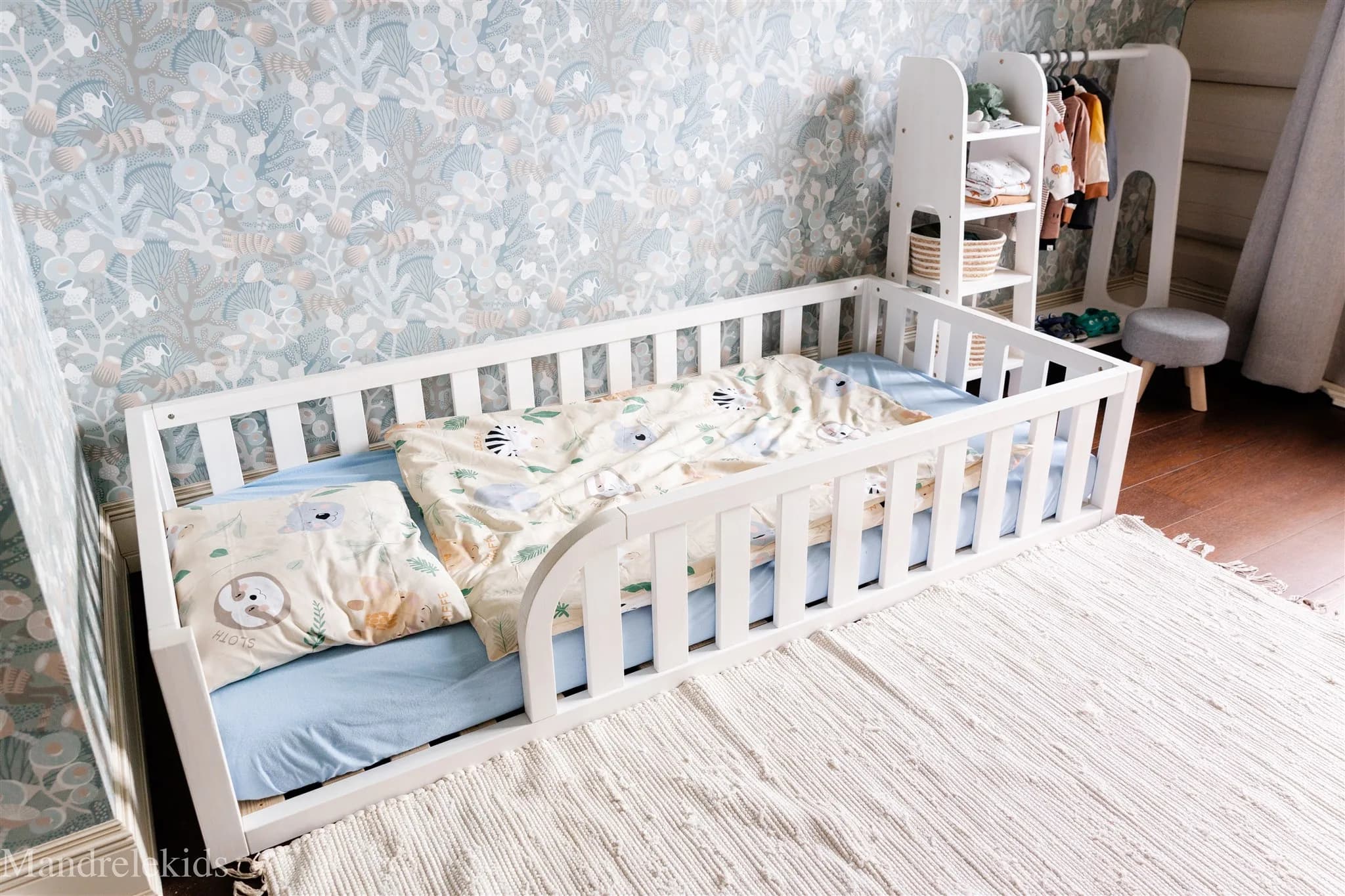 Lit de sol Montessori en bois naturel avec entrée arrondie et bords de protection pour la chambre d'enfant