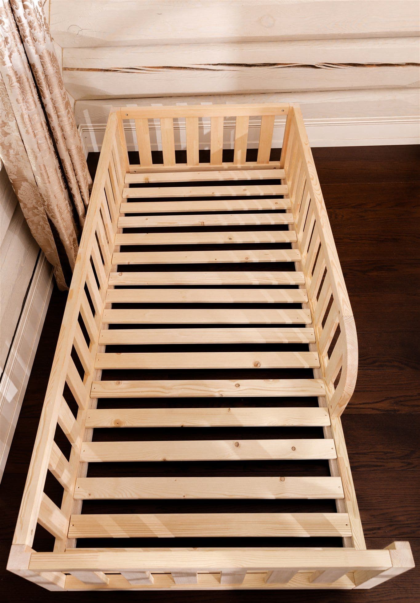 Lit de sol Montessori en bois naturel avec entrée arrondie et bords de protection pour la chambre d'enfant