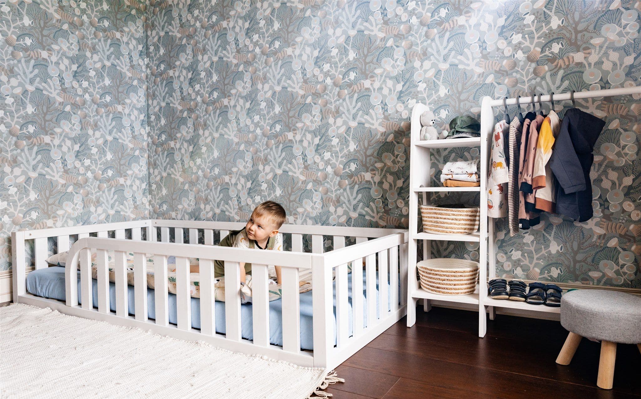 Lit de sol Montessori en bois naturel avec entrée arrondie et bords de protection pour la chambre d'enfant