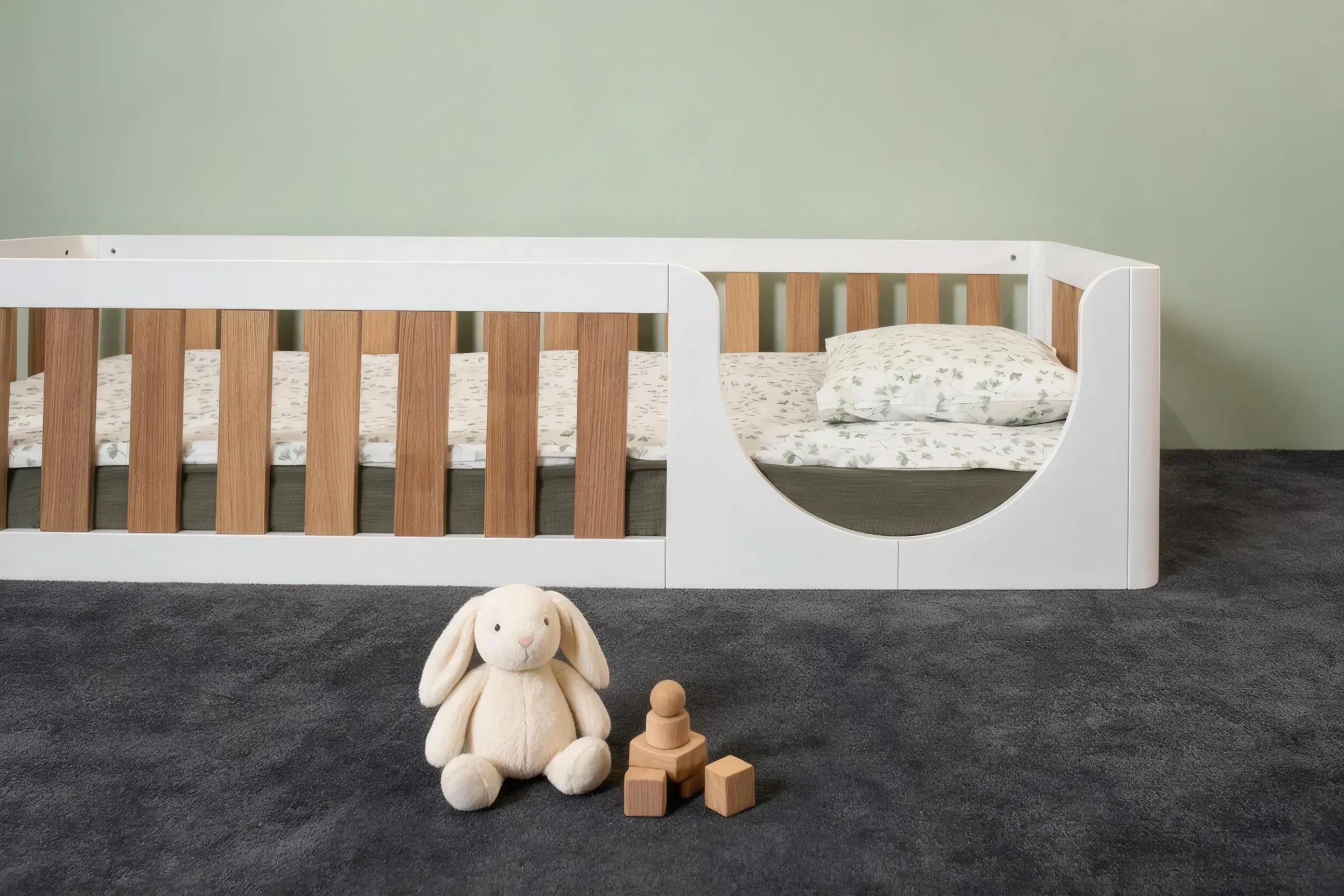 Letto a terra bianco con sbarre impiallacciate in rovere e ingresso semicircolare, vista frontale