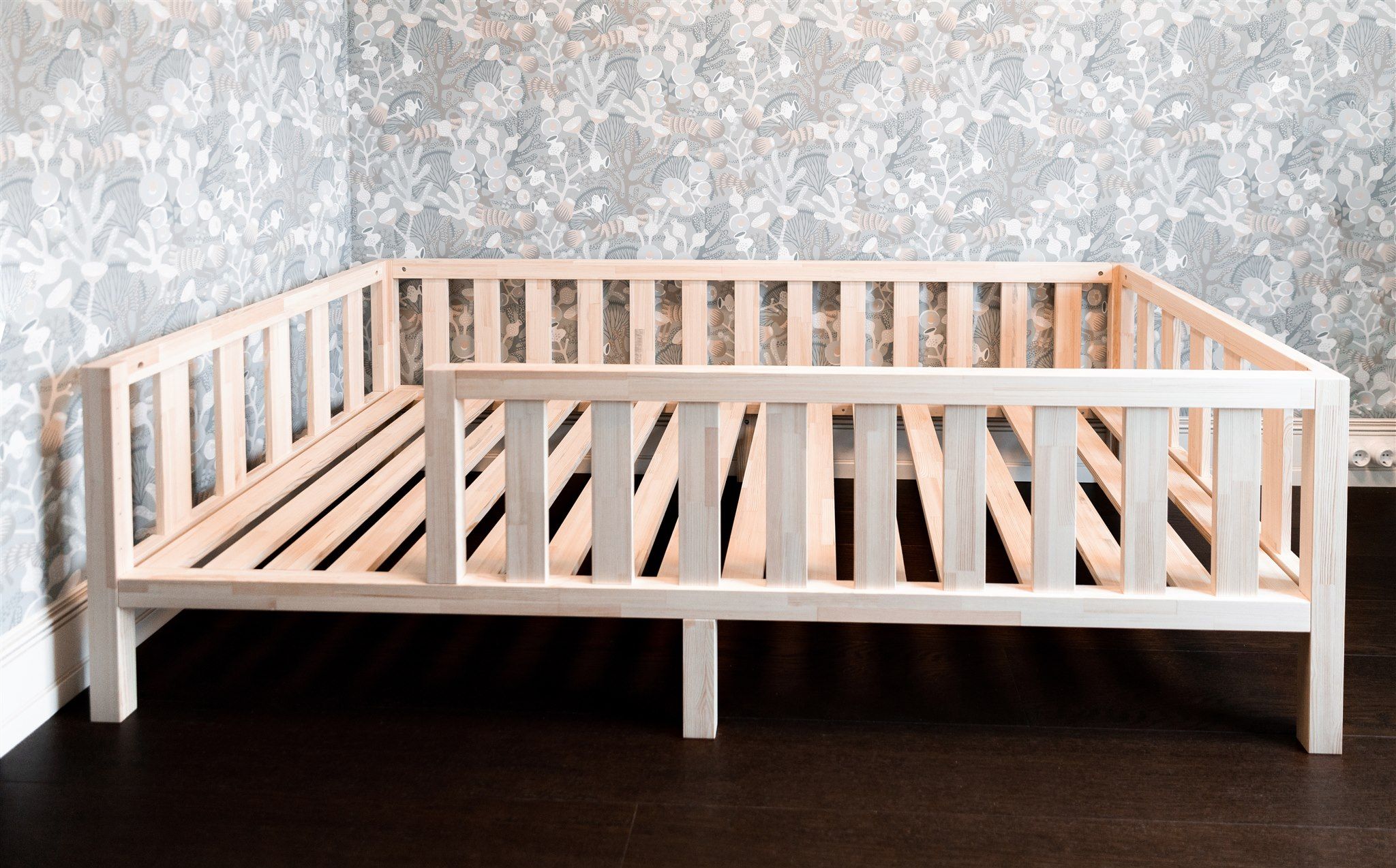 Naturalne łóżko Montessori z drewna sosnowego na nóżkach z barierkami ochronnymi, widok z boku