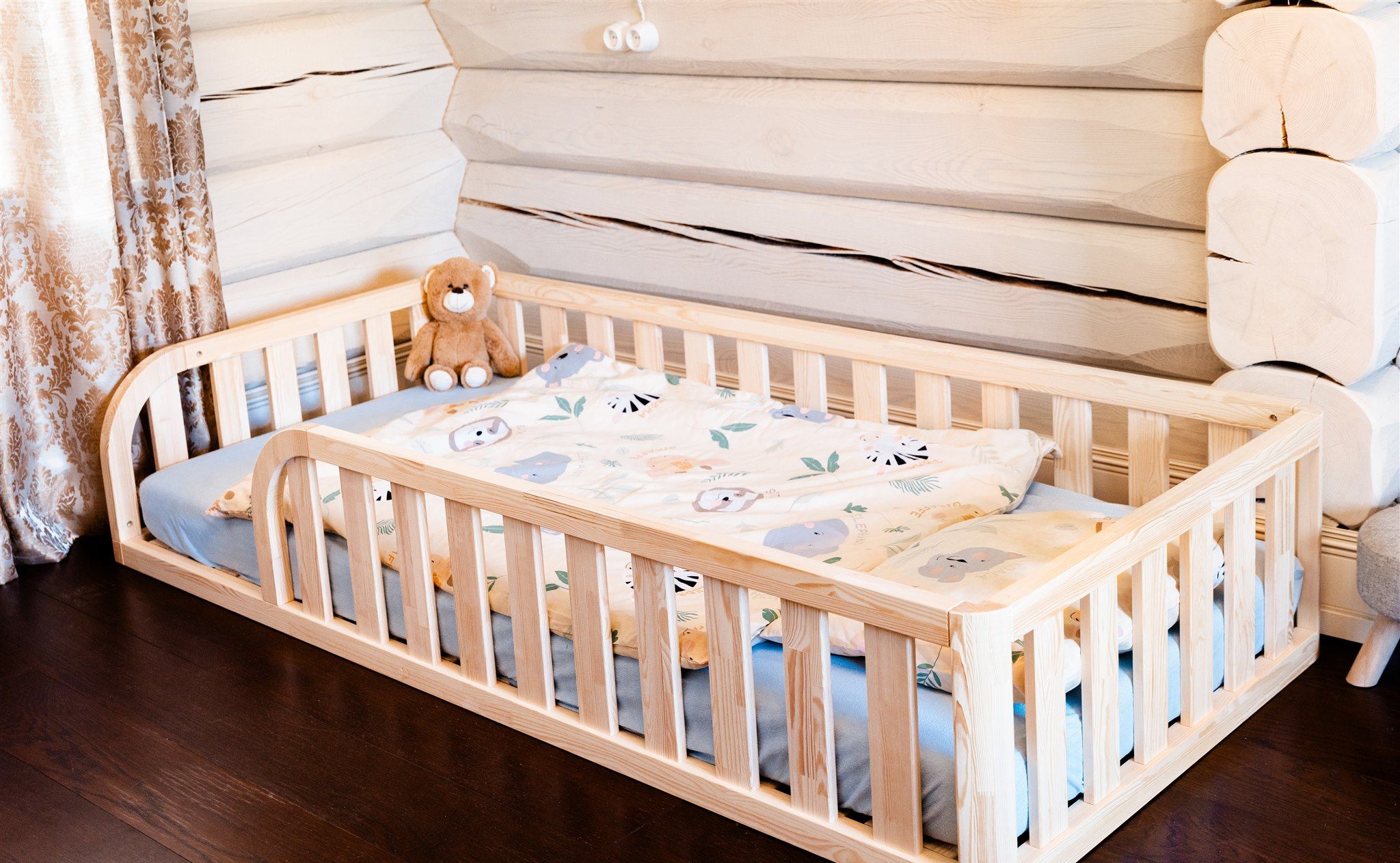 Cama de suelo Montessori de pino con entrada redondeada por ambos lados y oso de peluche