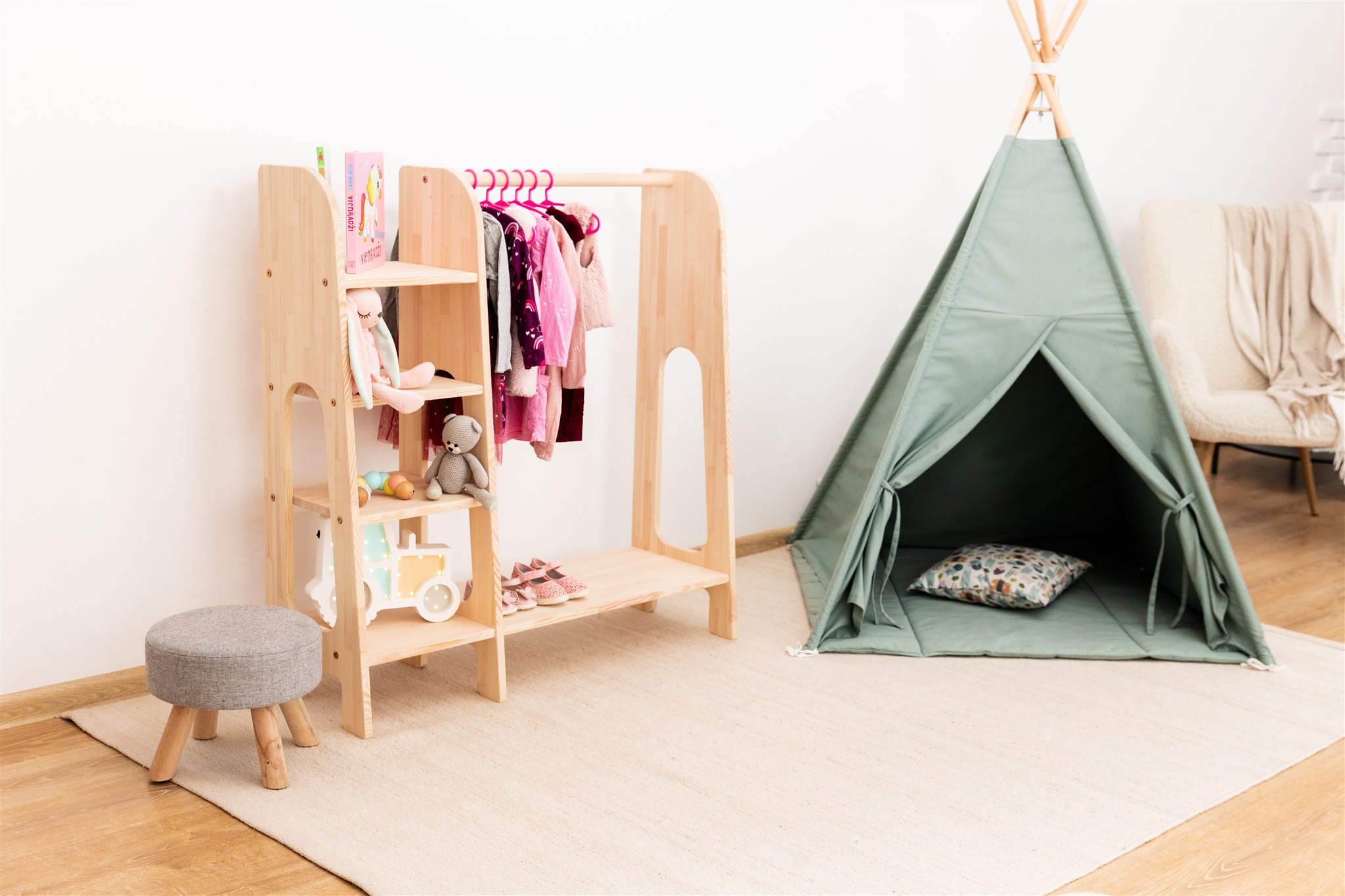 Perchero de pino para ropa infantil con estantes para la habitación de los niños junto al tipi