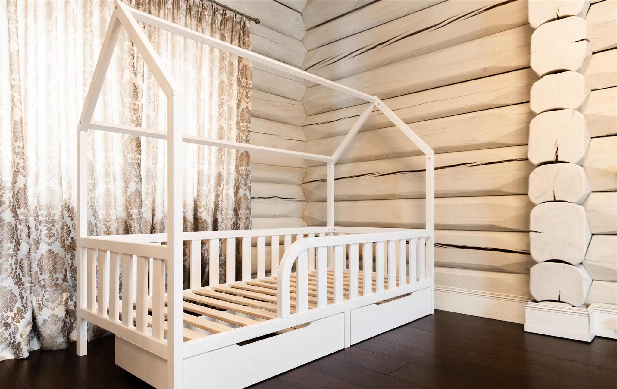 Cama casita blanca con cajones y listones de madera, vista en ángulo