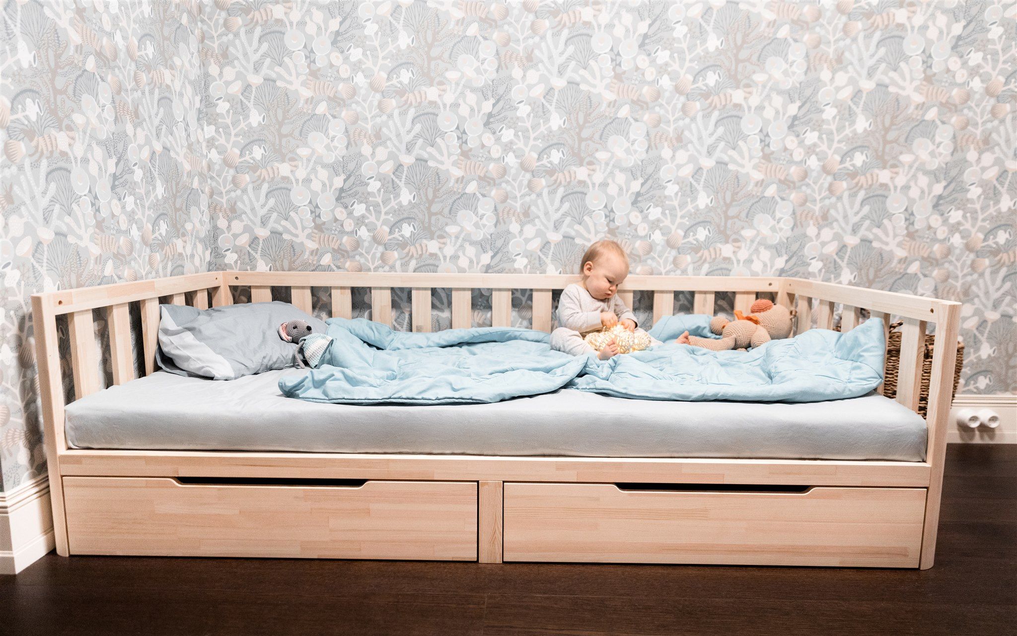 Bambini su letto Montessori in pino con fronte aperto e cassetti