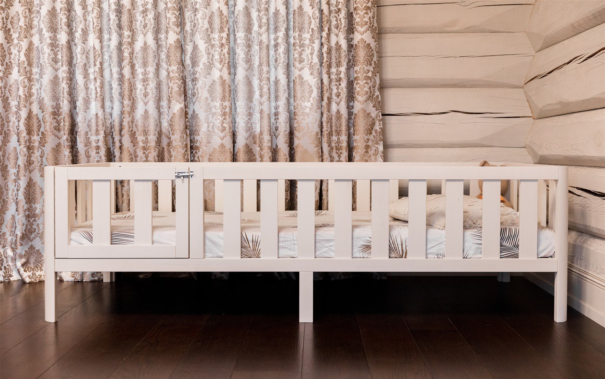 Letto Montessori bianco su gambe con cancelletto, vista laterale