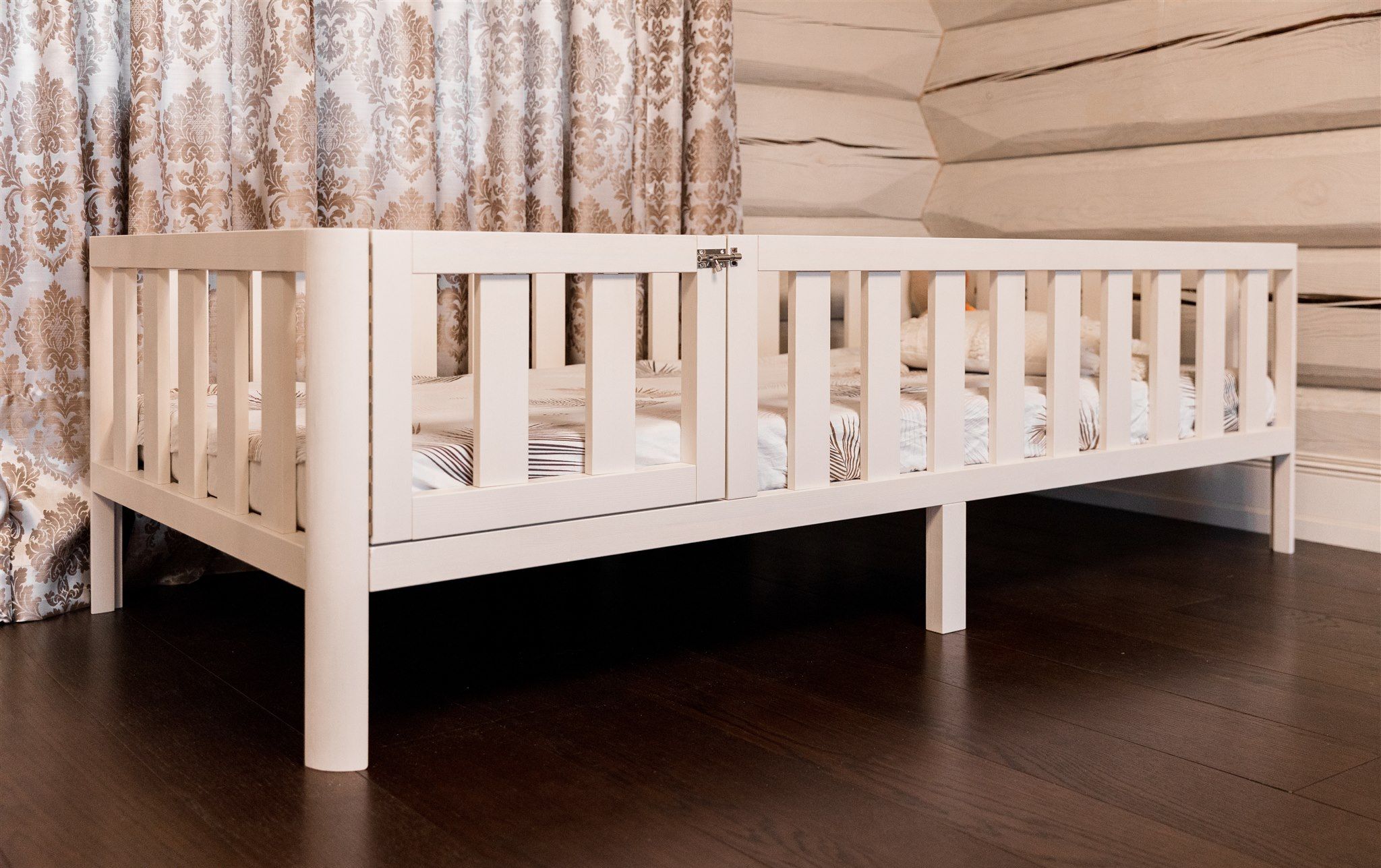 White solid wood Montessori toddler bed frame with rounded corners, safety guardrails, slatted base, and two under-bed storage drawers