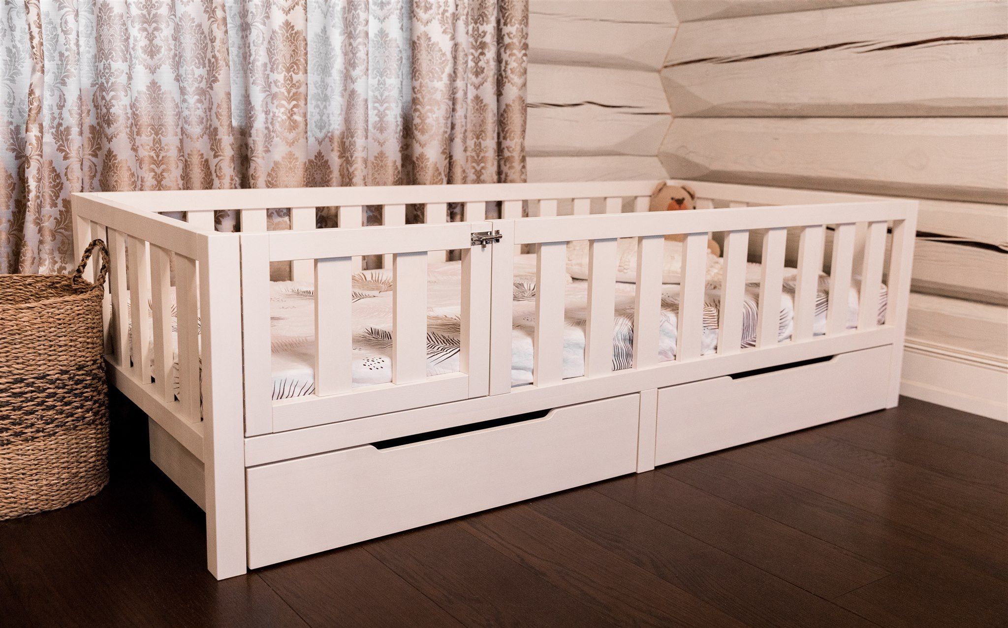 Letto Montessori bianco con ante chiuse e due cassetti, vista angolare